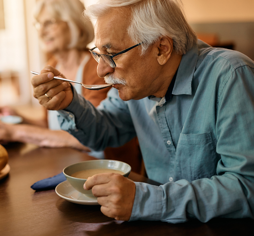 mature man eating low sodium soup
