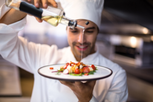 chef pours olive oil on umami food